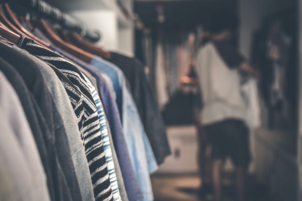 Person kigger på sit tøj i garderobe